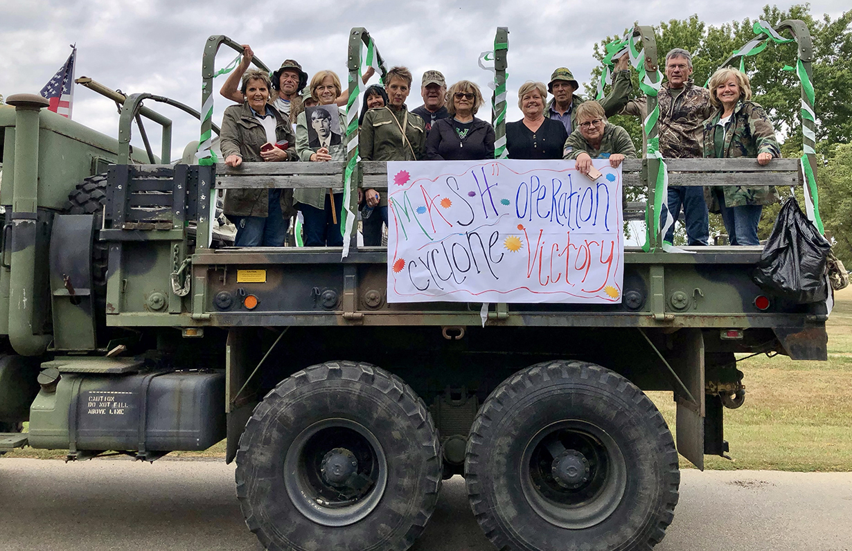 class of 1975 in back of humvee