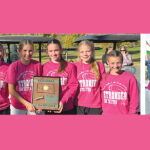seven teens in hot pink shirts lined up with plaque