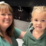 adult and young child both in green tops