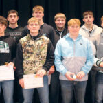 group of male teens holding awards