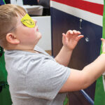 young boy pinning the heart on the grinch